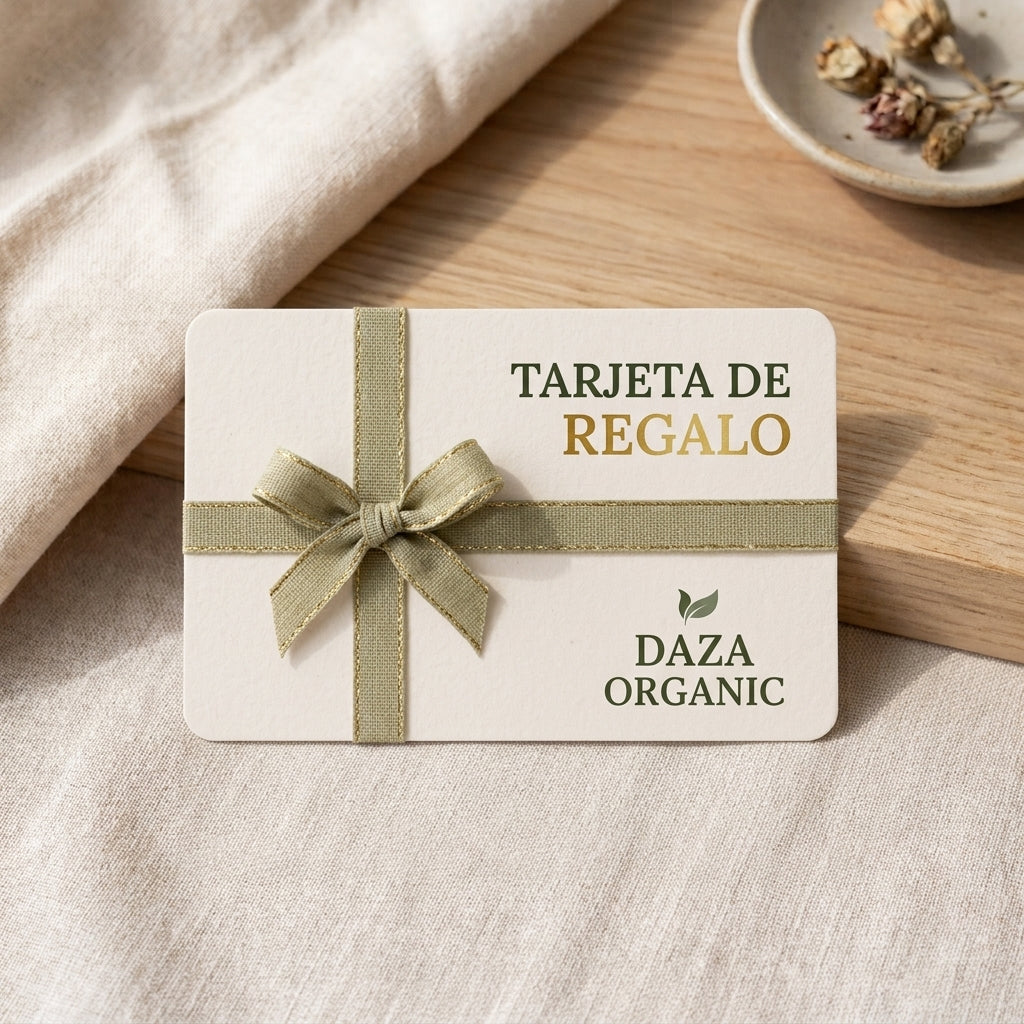 Tarjeta de regalo de Daza Organic, color crema, atada con una cinta verde salvia en forma de lazo, sobre un lino claro y una tabla de madera.